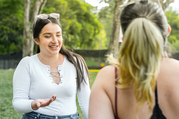 Fototapeta premium close-up of two friends chatting and laughing a lot while talking in a park