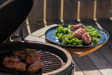 ready to eat - lamb's lettuce, red onions and roasted meat from a red deer calf on a black plate