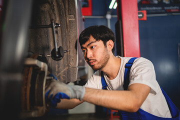 Close-up, Auto mechanic repairman using a socket wrench working engine repair in the garage, change spare part, check the mileage of the car, checking and maintenance service concept.