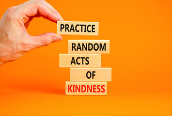 Practice random kind of kindness symbol. Concept words Practice random kind of kindness on wooden block. Beautiful orange background. Businessman hand. Business practice kindness concept. Copy space.