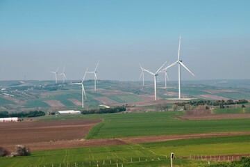Wind turbine and windmill. Clean energy in green nature in different locations. Sustainability and...