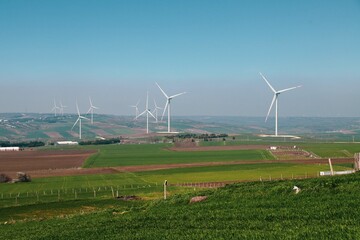 Wind turbine and windmill. Clean energy in green nature in different locations. Sustainability and environment concept
