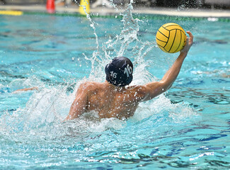 Young boys swimming and playing in an exciting game of Water Polo 