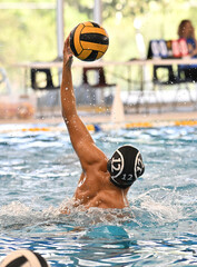 Young boys swimming and playing in an exciting game of Water Polo 