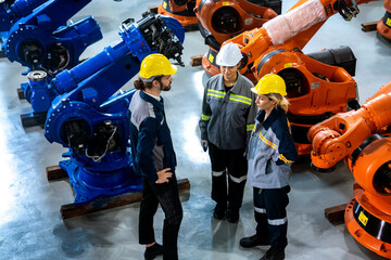 Male engineer talking to a group of men and women team meeting discuss maintenance plan of robotic...