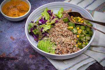 Protein bowl consisting of buckwheat, hemp seeds, okra and corn stir fry, salad and avocado