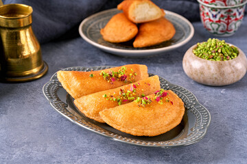 Arabian pancake Qatayef with cheese and pistachio . Traditional ramadan sweets .