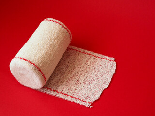 Medical bandage roll isolated on red background