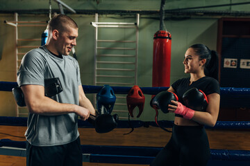 Man and a woman are putting their boxing gloves on