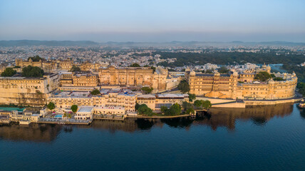Fototapeta na wymiar Aerial view city palace in Udaipur during sunrise, known for its beautiful lakes, palaces, and historical significance. The city was founded in 1559.