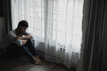 Sad young man sitting in the bedroom, People with depression concept, stressed man,	