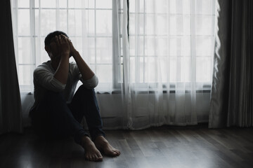Fototapeta na wymiar Sad young man sitting in the bedroom, People with depression concept, stressed man, 