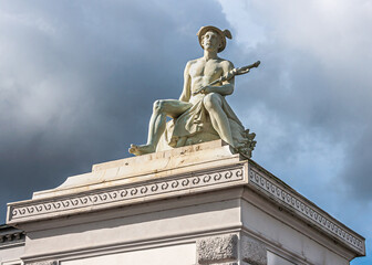 Obraz premium Copenhagen, Denmark - September 13, 2010: Mercurius or Hermes God white stone statue closeup on pillar at east side entrance to Churchill Parken under gray cloudscape