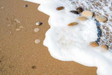 Nature photography on the shore of the beach with stones and sea foam