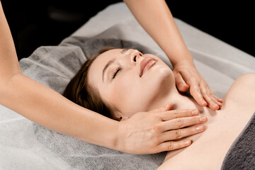 Neck and face massage in the spa. Masseur is making facial beauty treatments for attractive female model. Relaxation.