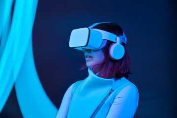Woman is using virtual reality headset to access in metaverse.