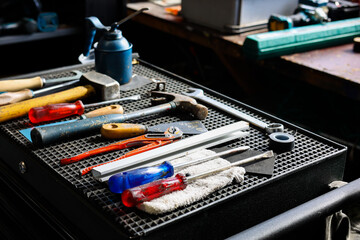set of DIY equipment tools on manual  work station in garage workshop background.