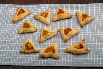 Sweet gomentashi cookies for the Purim holiday on a chalkboard laid out on a gray napkin.