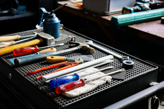 set of DIY equipment tools on manual  work station in garage workshop background.