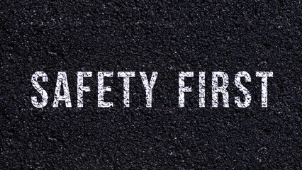 Fototapeta premium Safety first text written on the road in middle of the asphalt road, Safety first word on street.