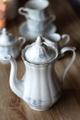 Vintage white tea set with pale blue flowers. Selective focus.
