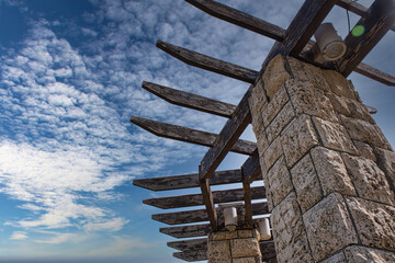 Part of a wooden pergola against a cloudy sky. Copy space.