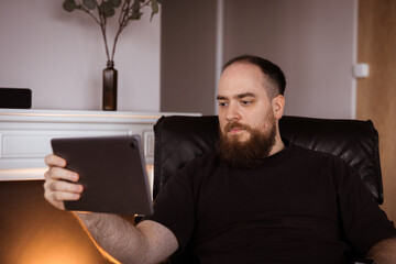Man reading on the tablet cozy at home