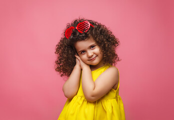 portrait of a girl in a yellow dress cute attractive cute cheerful cheerful little girl .isolated pink background.