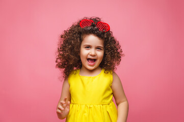 portrait of a girl in a yellow dress cute attractive cute cheerful cheerful little girl .isolated pink background.