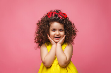 portrait of a girl in a yellow dress cute attractive cute cheerful cheerful little girl .isolated pink background.