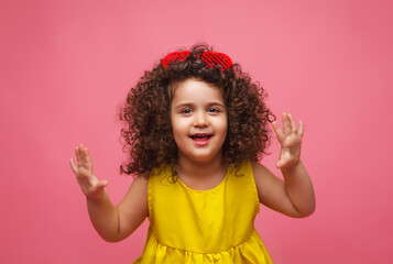 portrait of a girl in a yellow dress cute attractive cute cheerful cheerful little girl .isolated pink background.