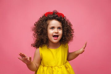 portrait of a girl in a yellow dress cute attractive cute cheerful cheerful little girl .isolated pink background.