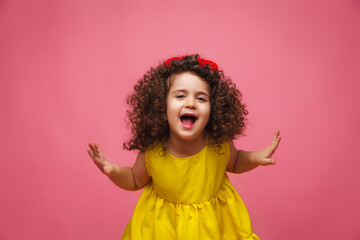 portrait of a girl in a yellow dress cute attractive cute cheerful cheerful little girl .isolated pink background.