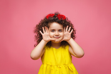 portrait of a girl in a yellow dress cute attractive cute cheerful cheerful little girl .isolated pink background.