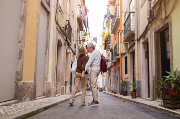 Senior Couple Kissing On Street Traveling On Vacation Standing Outdoors