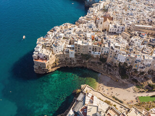 People bathing in the sun in Blue Lagoon, Polignano a Mare the beach. Aerial view of swimming in...