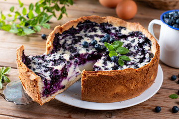 Blueberry pie and berries on wooden table