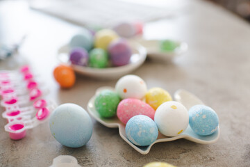 Fototapeta na wymiar Colorful Easter eggs in rabbit shape plate on kitchen table closeup. Holiday celebration.