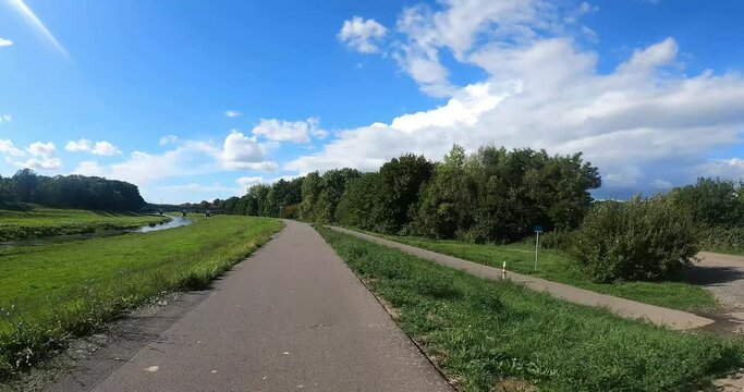 bike path on embankment of river elster in leipzig with arched bridge 4k