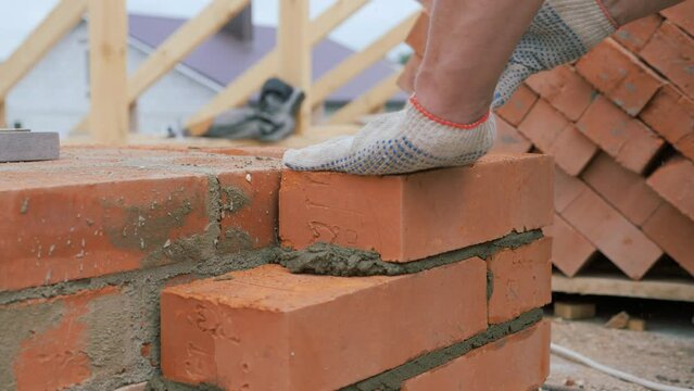 Laying out a brick chimney chimney of a private wooden house.