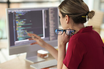 Female programmer checkups code working on computer