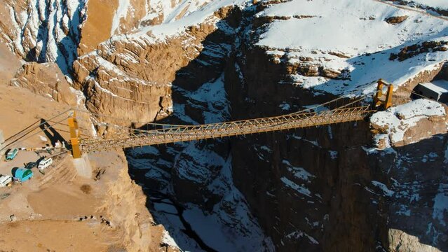 4K aerial view of Chicham bridge connecting Kibber and Chicham villages in Spiti Valley, India. Highest suspension bridge of Asia. Spectacular high aerial view of Chicham Bridge during winter.