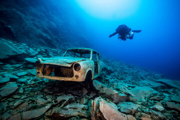 Trabant Autowrack in einem ehemaligen Steinbruch unter Wasser mit Taucher im Hintergrund - obrazy, fototapety, plakaty