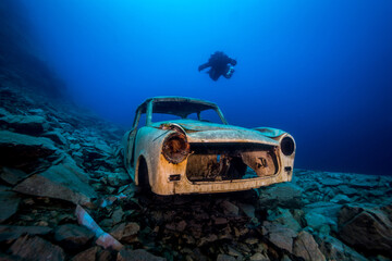 Trabant Autowrack in einem ehemaligen Steinbruch unter Wasser mit Taucher im Hintergrund