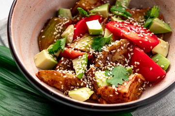 Fried eggplant with avocado, tomatoes and sesame seeds. Asian cuisine.