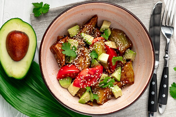 Fried eggplant with avocado, tomatoes and sesame seeds. Asian cuisine.