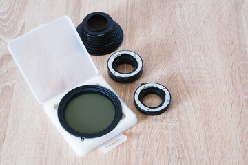 Neutral density filter, filter adapters and macro photo rings on wooden table, photography theme, visual communication, top side view