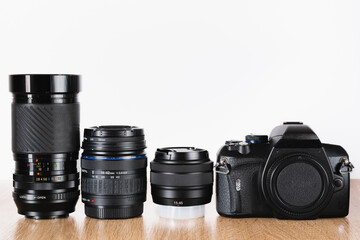 Camera and photographic lenses lined up on wooden table, horizontal photography, photography theme, visual communication