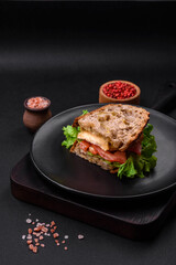 Delicious sandwich with crispy toast, chicken, tomatoes and lettuce
