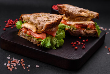 Delicious sandwich with crispy toast, chicken, tomatoes and lettuce
